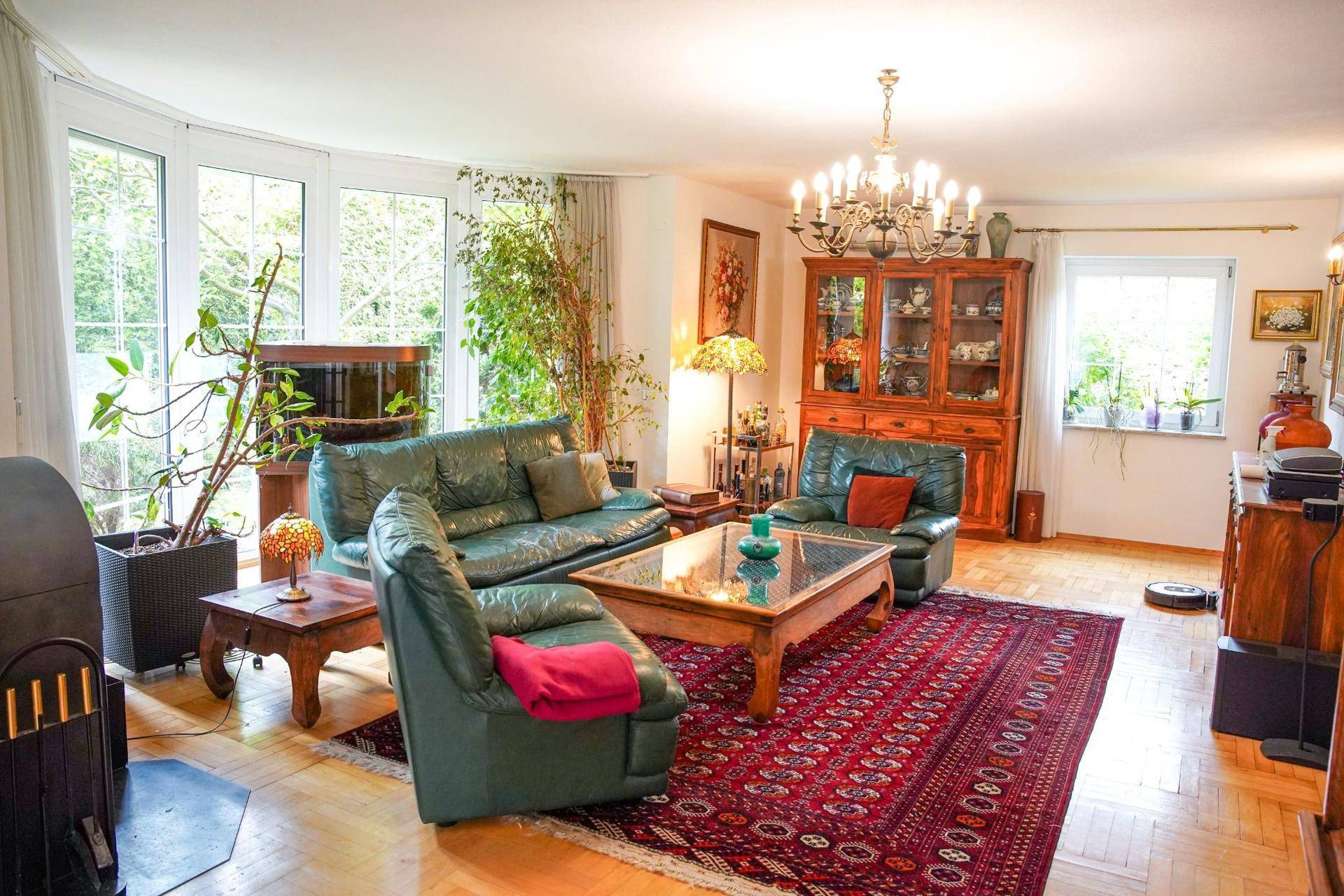 Gemütliches Wohnzimmer mit Ledersofas, Holzboden, Kamin und einem orientalischen Teppich.