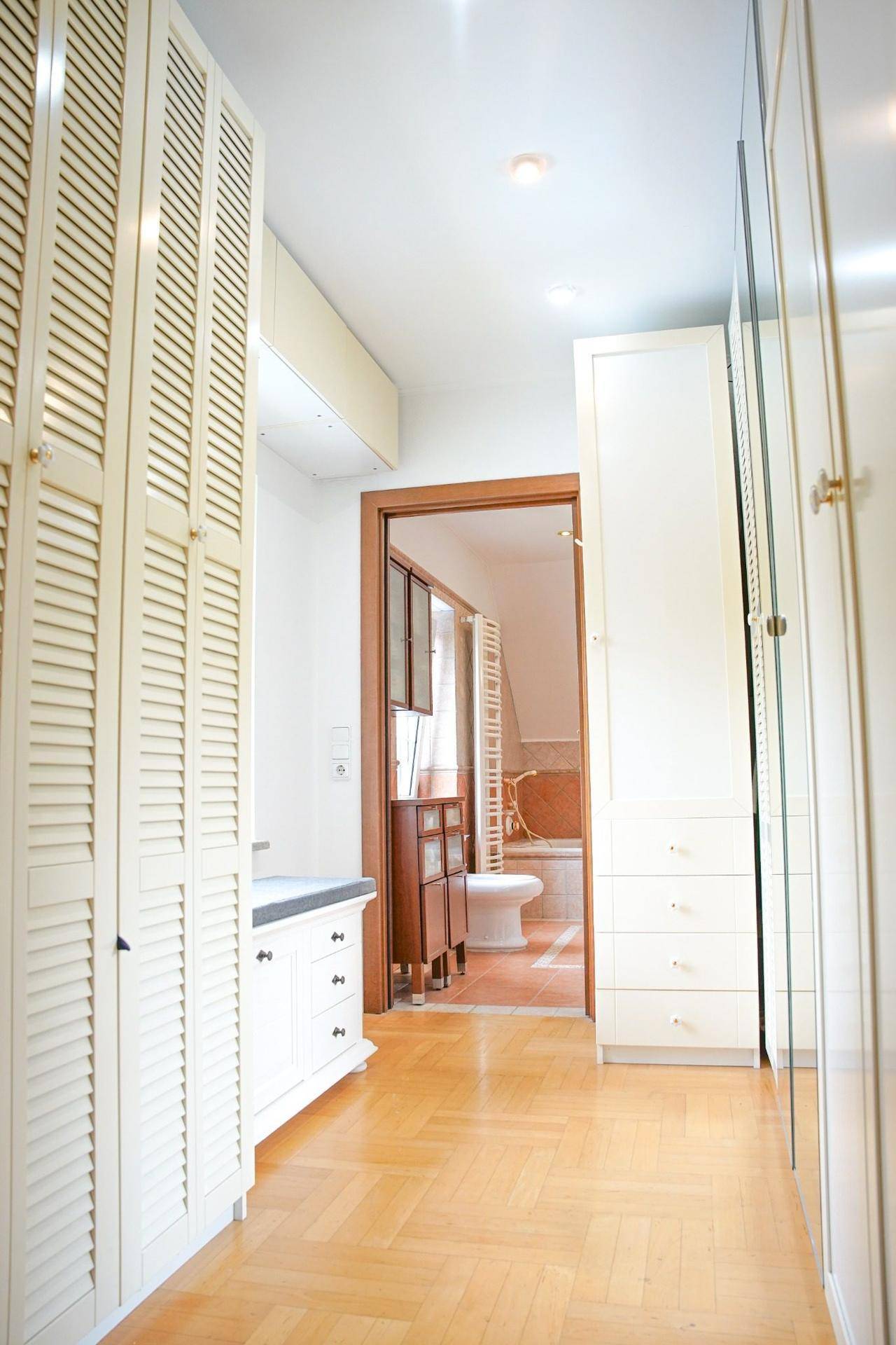 Flur mit Einbauschränken und Blick in ein Badezimmer.