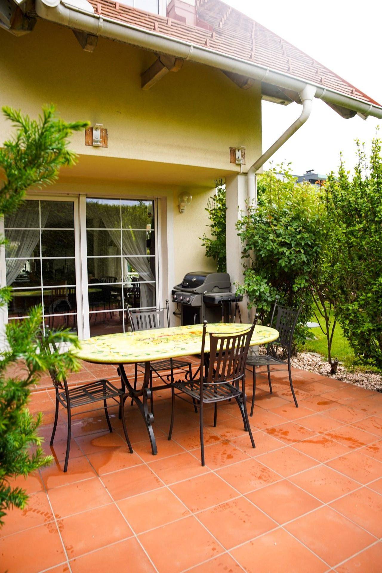 Geräumige Terrasse mit Terrakotta-Fliesen, Esstisch und Grillbereich für gesellige Abende.