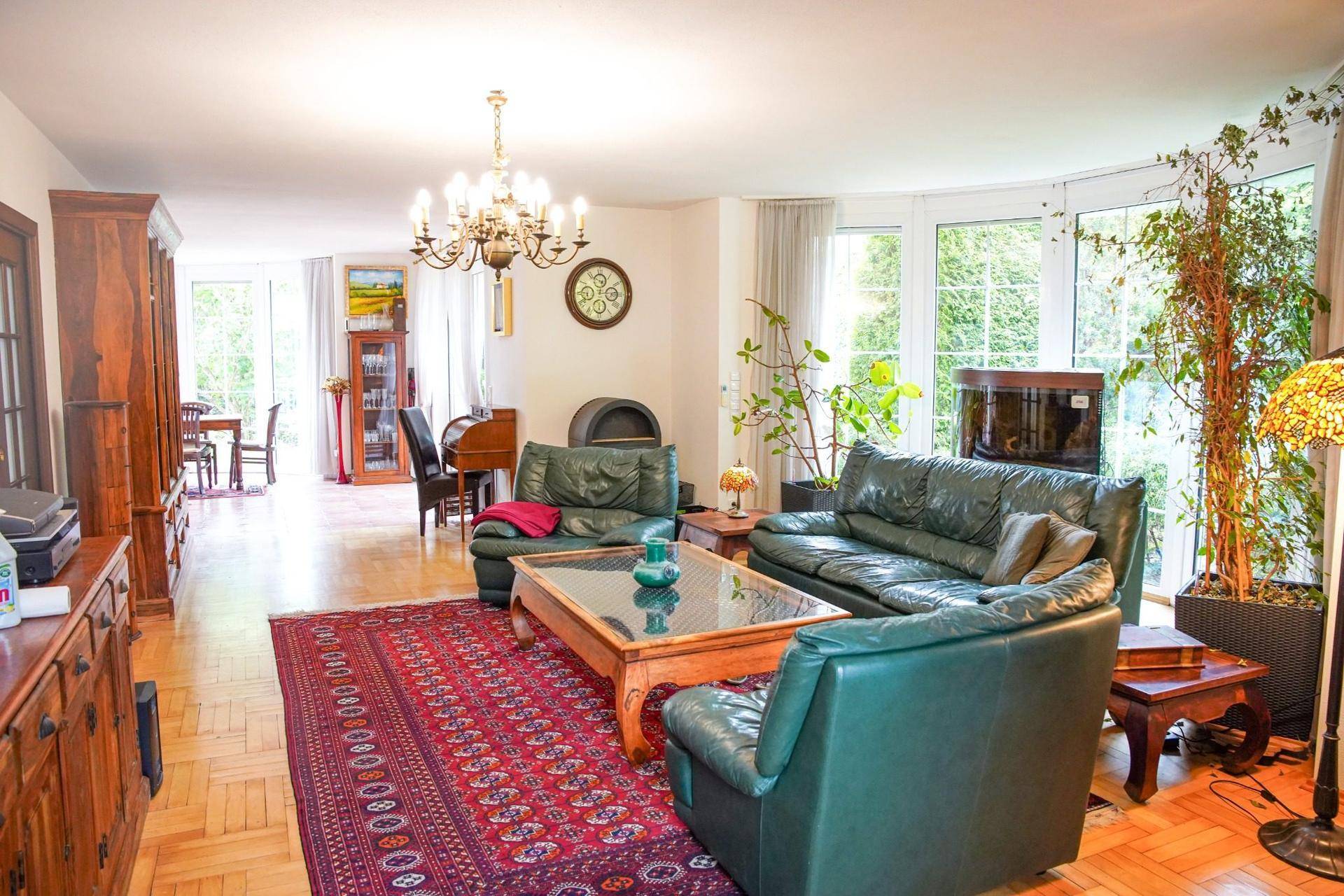 Geräumiger Wohnbereich mit Ledersofas, Holzboden und offenem Übergang zum Essbereich.