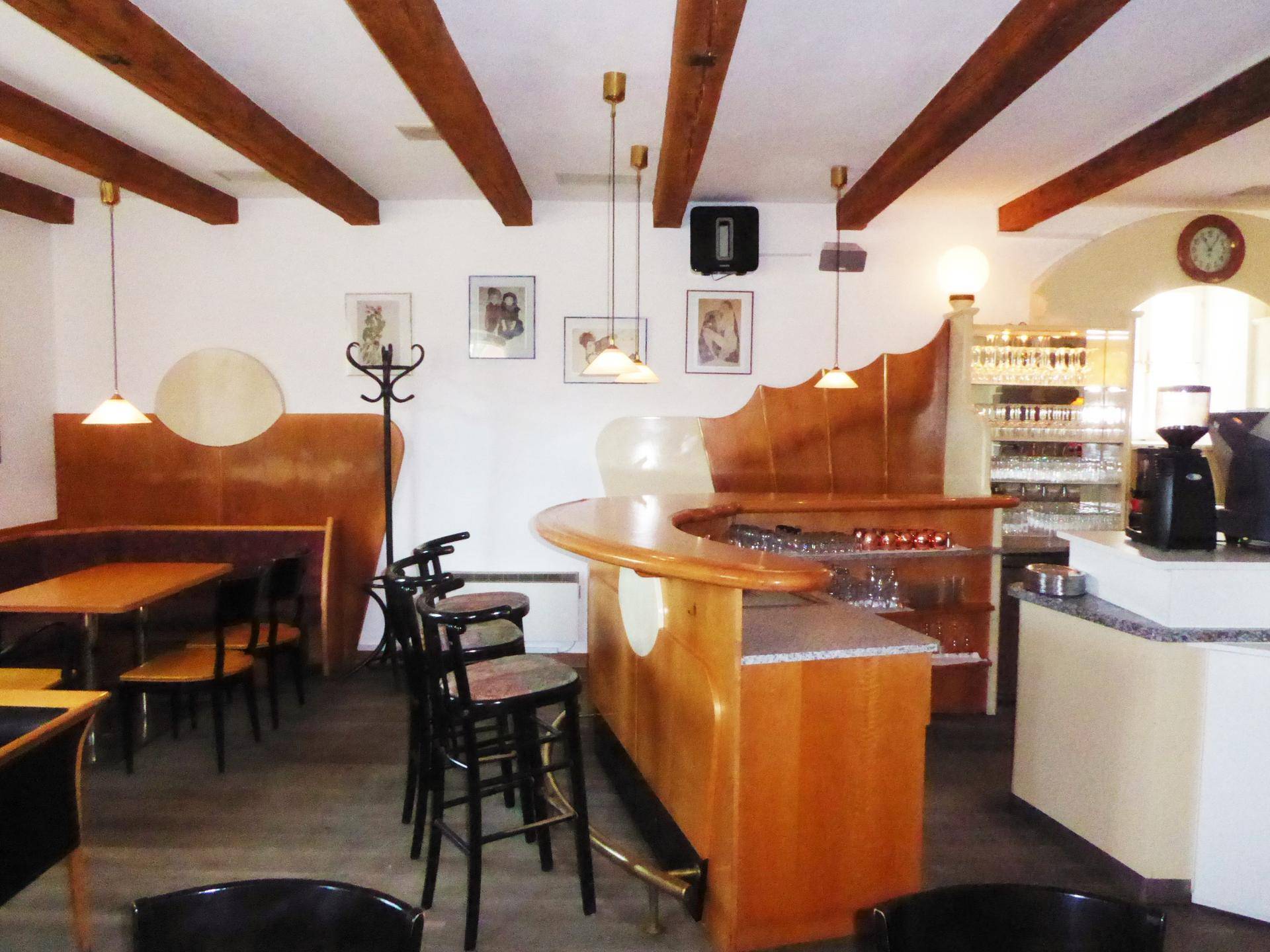 Gemütlicher Barbereich mit Holzbalken, Theke und Sitzgelegenheiten in einem traditionellen Stil.