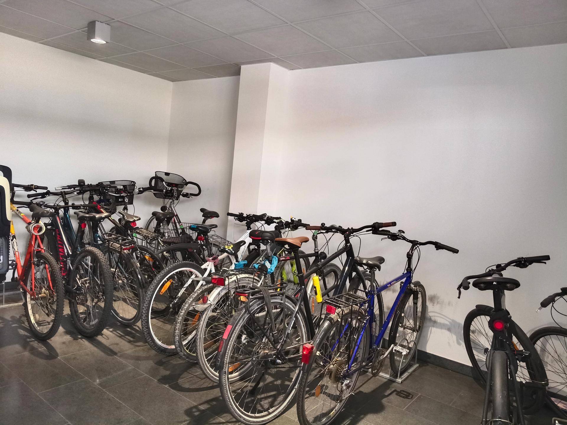 Gut organisierter Fahrradabstellraum mit vielen Fahrrädern an der Wand.