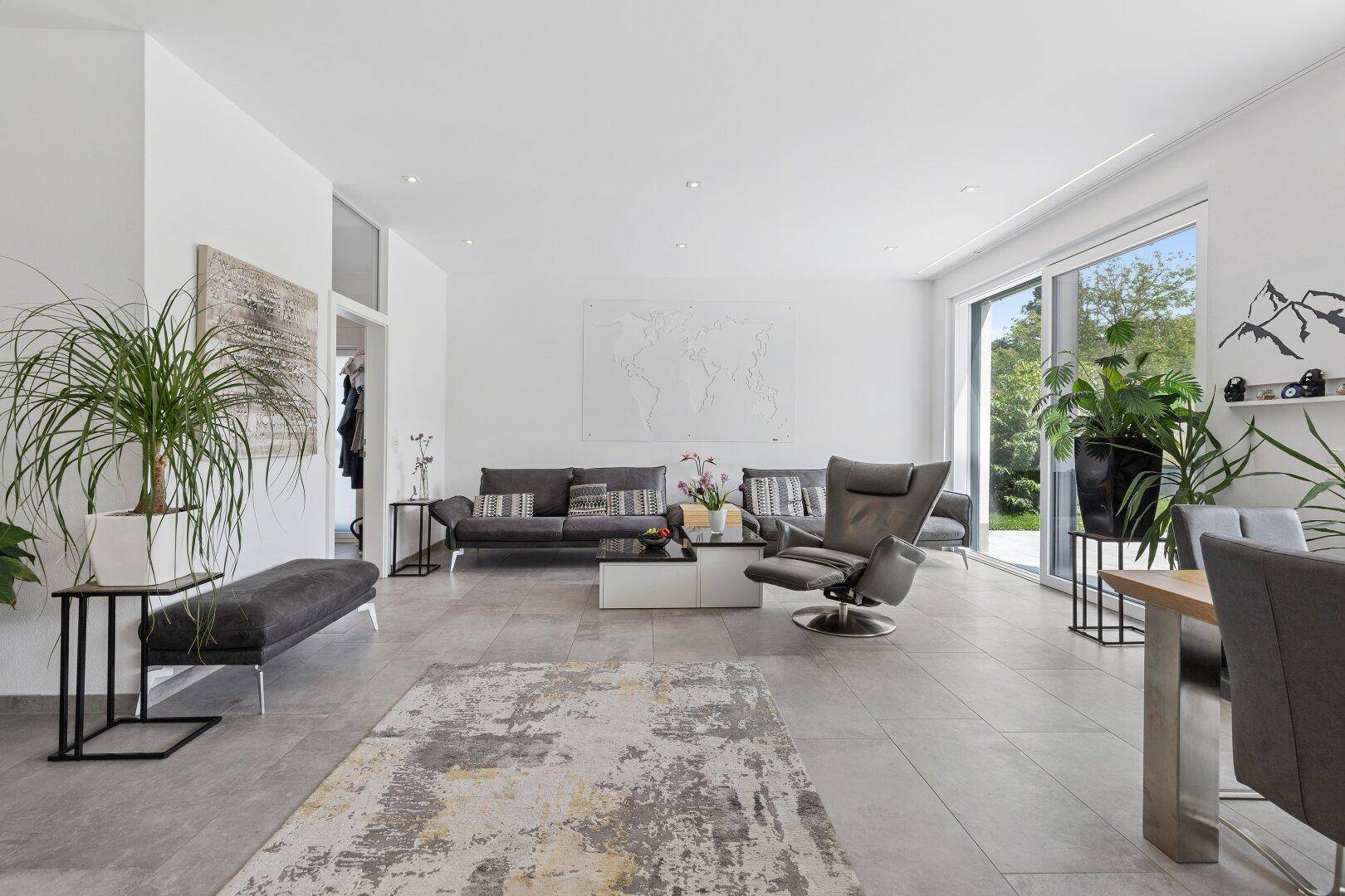 Weitläufiger Wohnbereich mit moderner Kunst an der Wand, bequemen Sofas und großen Pflanzen.