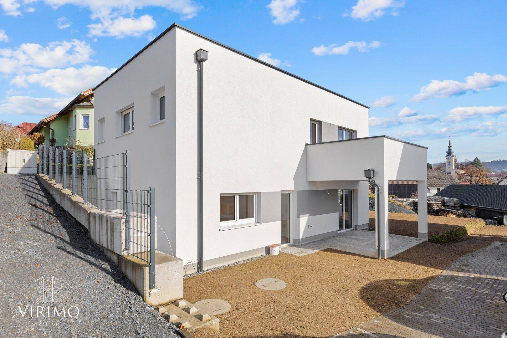 Moderne Neubau-Doppelhaushälfte mit Flachdach und gepflegter Außenanlage.