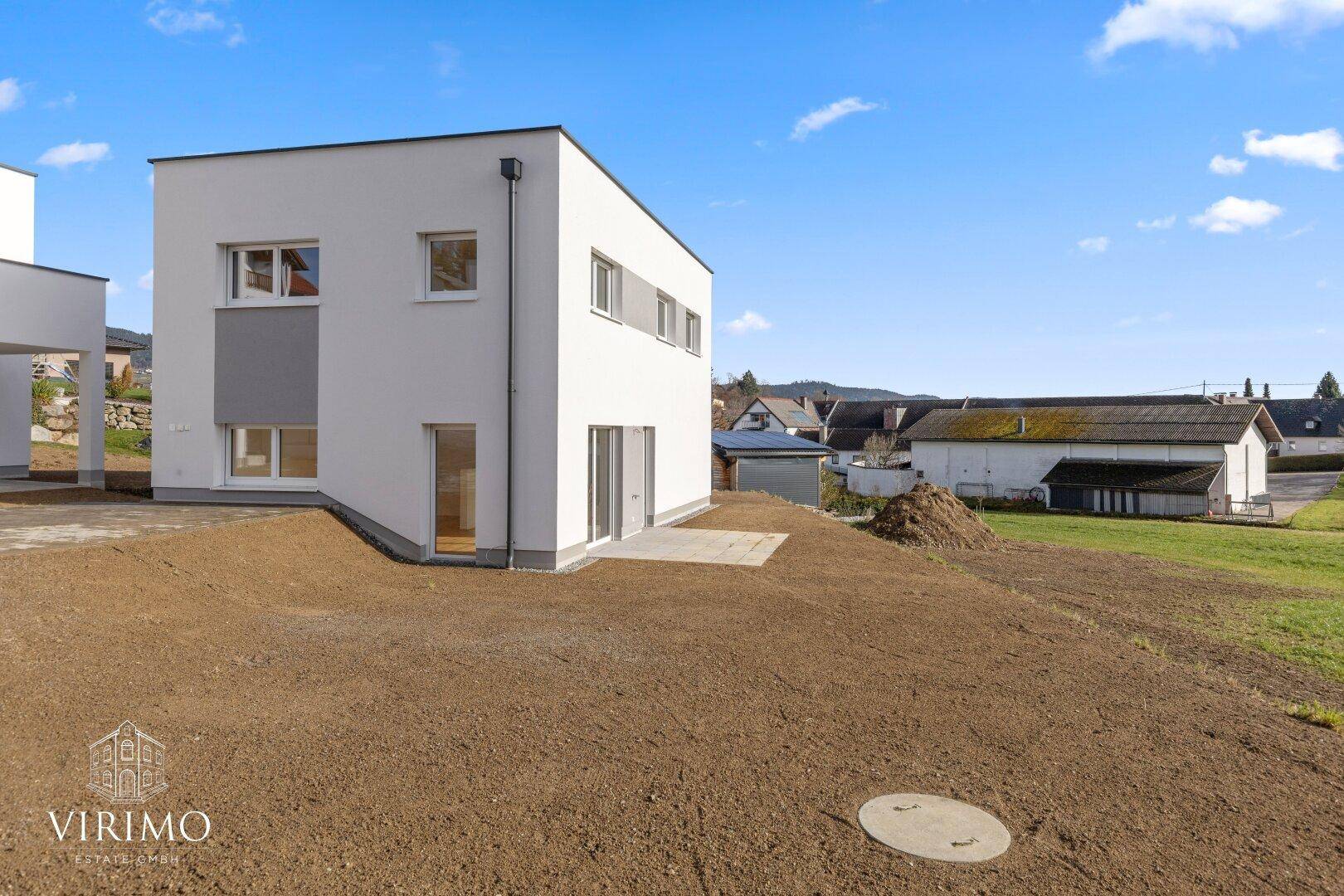 Neubau-Doppelhaushälfte mit moderner Architektur und großem Grundstück in ländlicher Umgebung.