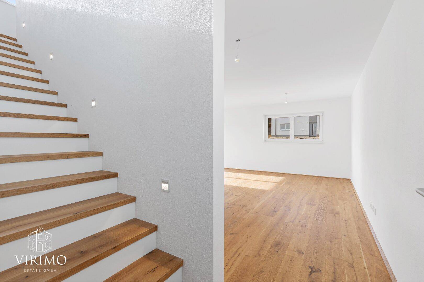 Moderne Holztreppe mit integrierter Beleuchtung führt zu den oberen Etagen des Hauses.