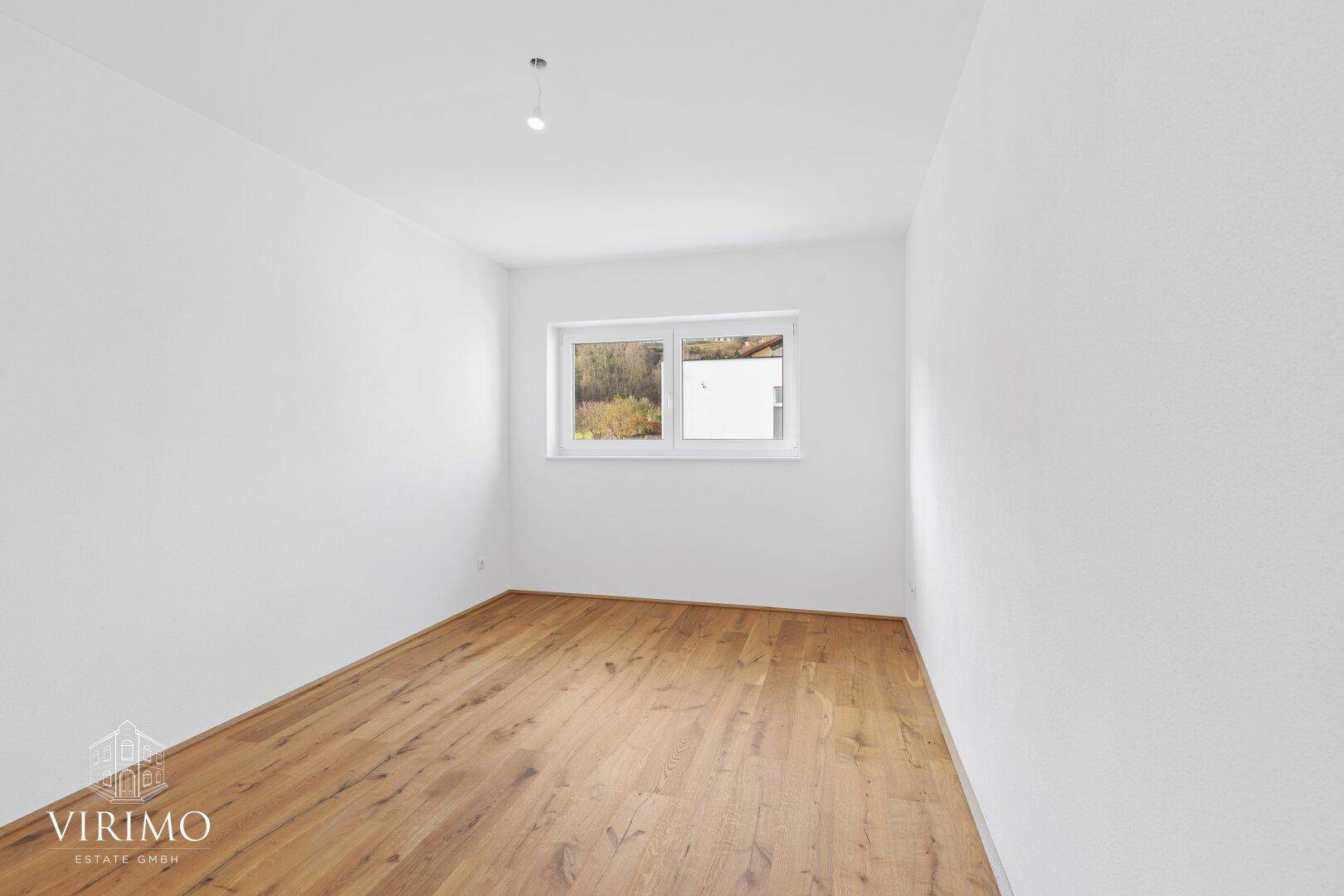 Ruhiges Schlafzimmer mit Holzboden und Fenster, ideal für erholsame Nächte.