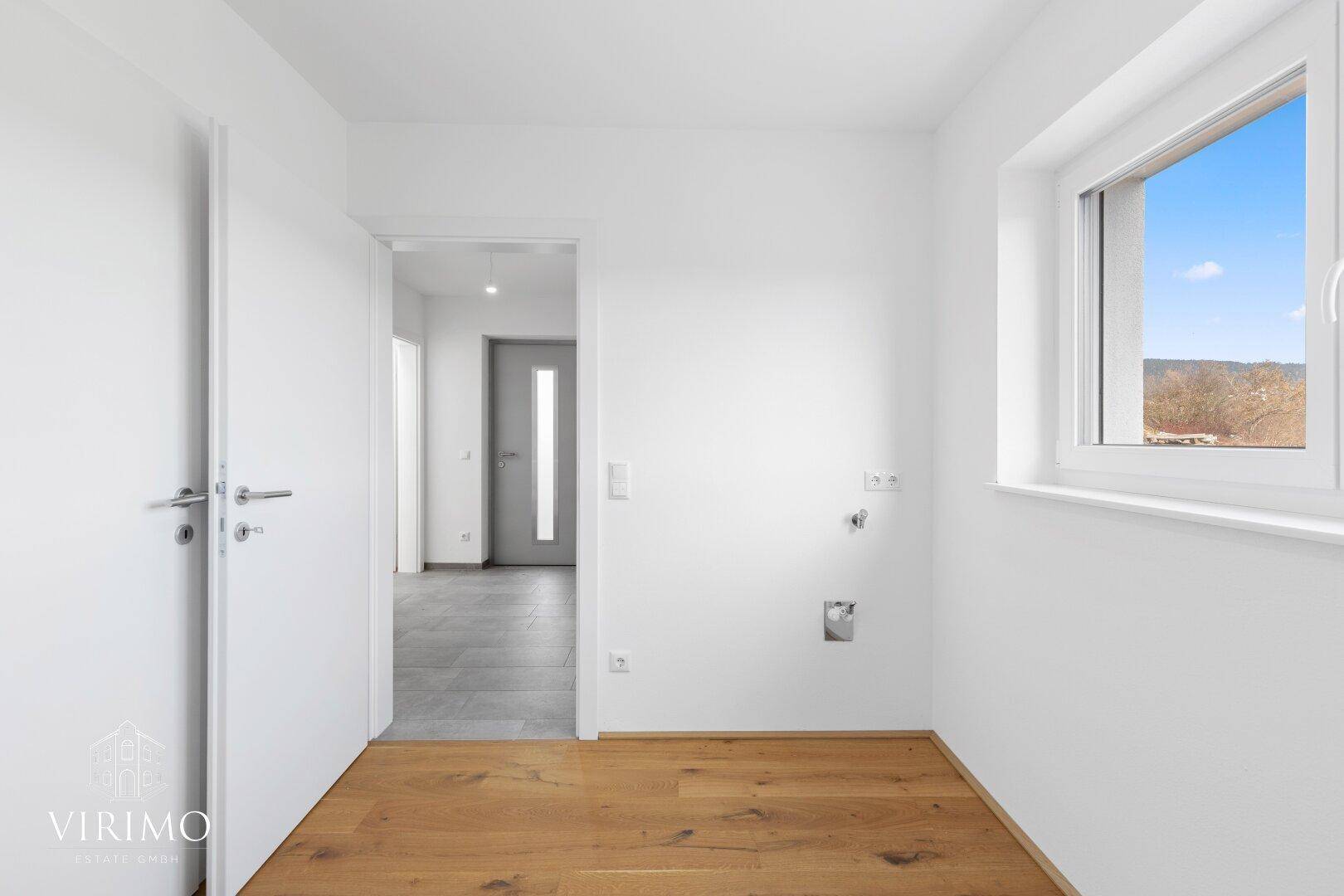 Praktischer Hauswirtschaftsraum mit Anschlüssen für Waschmaschine und Trockner, hell und funktional.