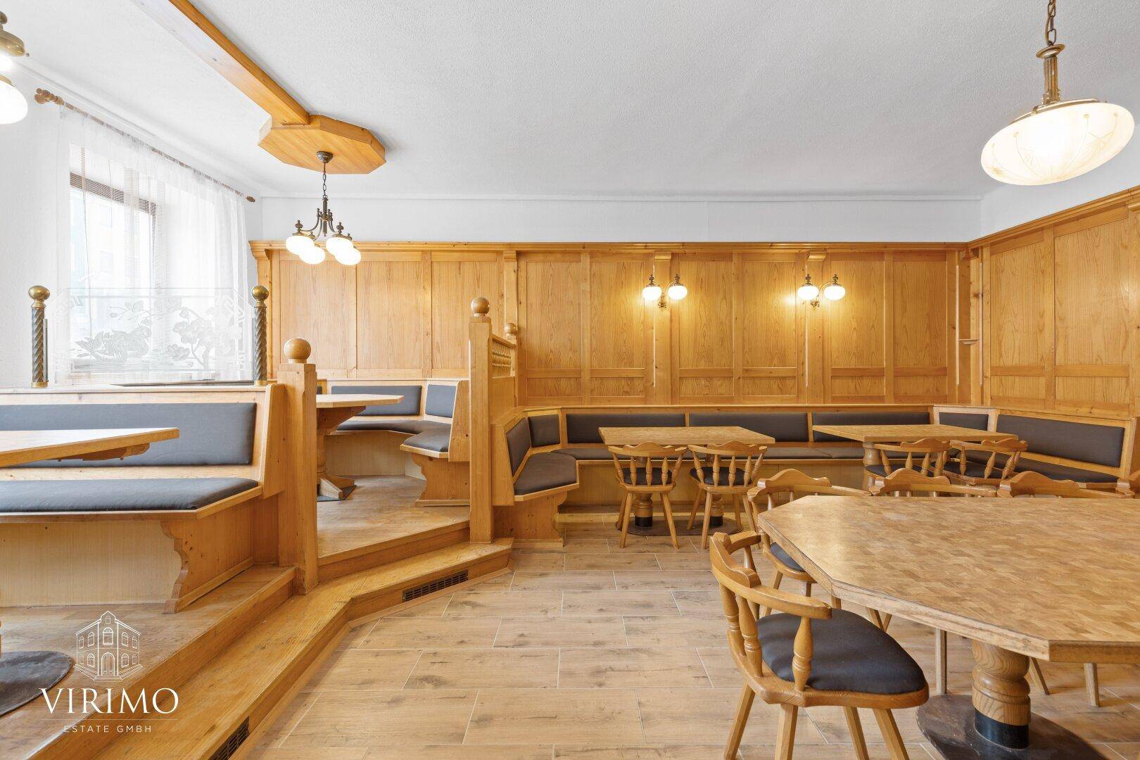 Gemütlicher Gastraum mit Holztäfelung, Eckbänken und traditionellen Tischen.