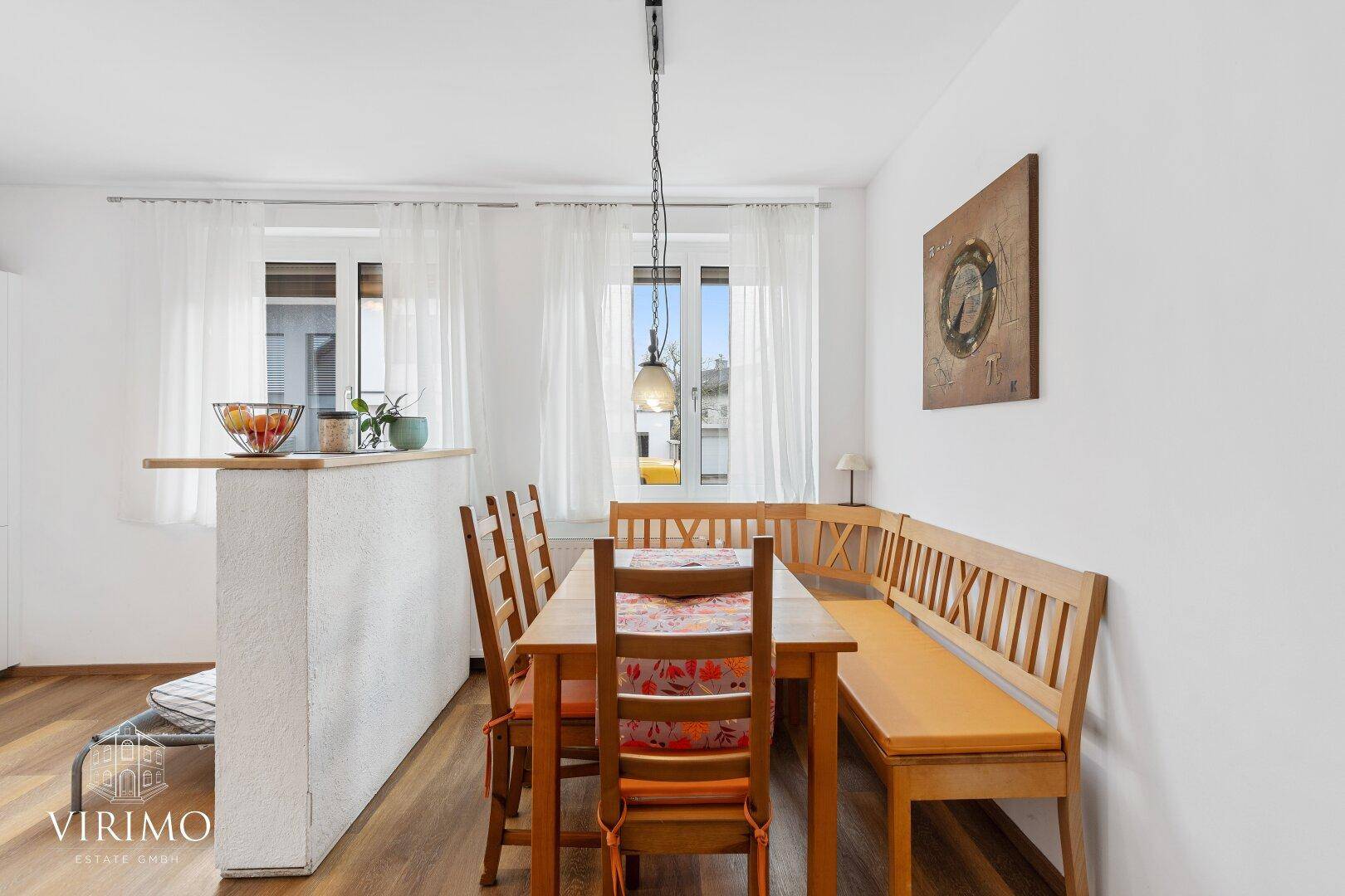 Gemütlicher Essbereich mit Holztisch, Eckbank und viel Tageslicht durch die Fenster.