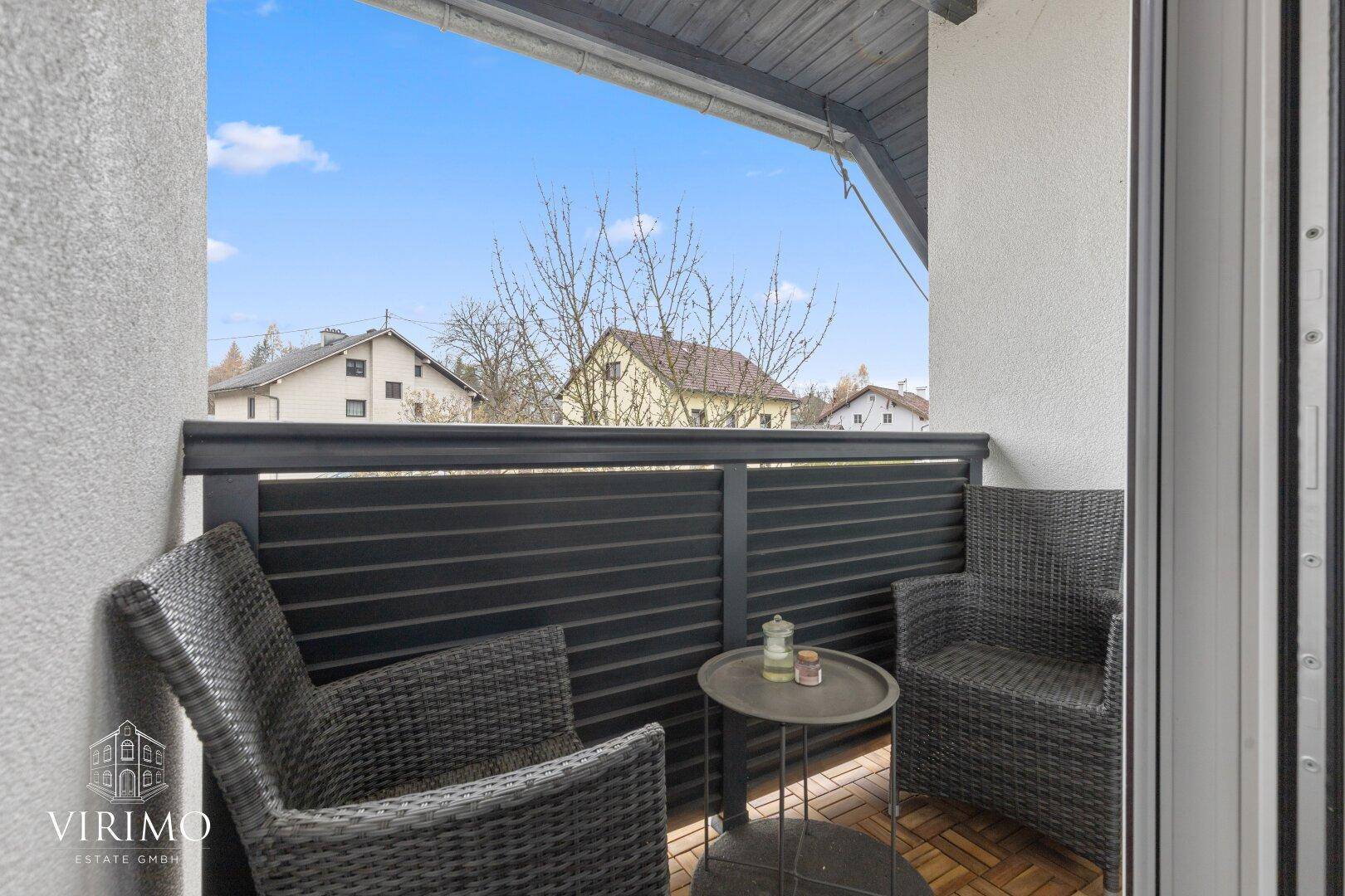 Kleiner Balkon mit Sitzgelegenheiten und Blick auf die Nachbarschaft.