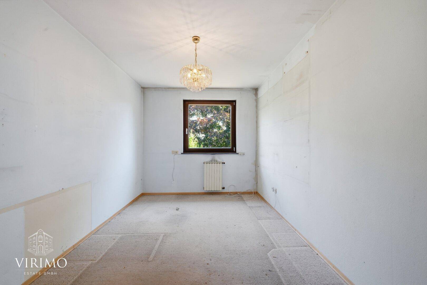 Heller Raum mit Fenster und Kronleuchter, bereit für neue Gestaltung.