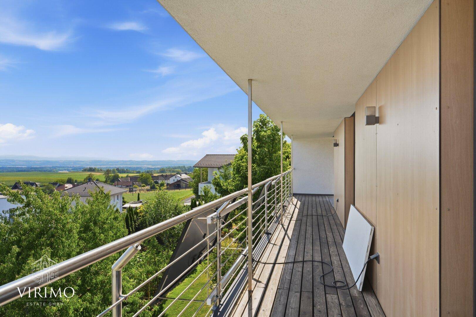 Langer Balkon mit Holzboden und Edelstahlgeländer, bietet weite Ausblicke.