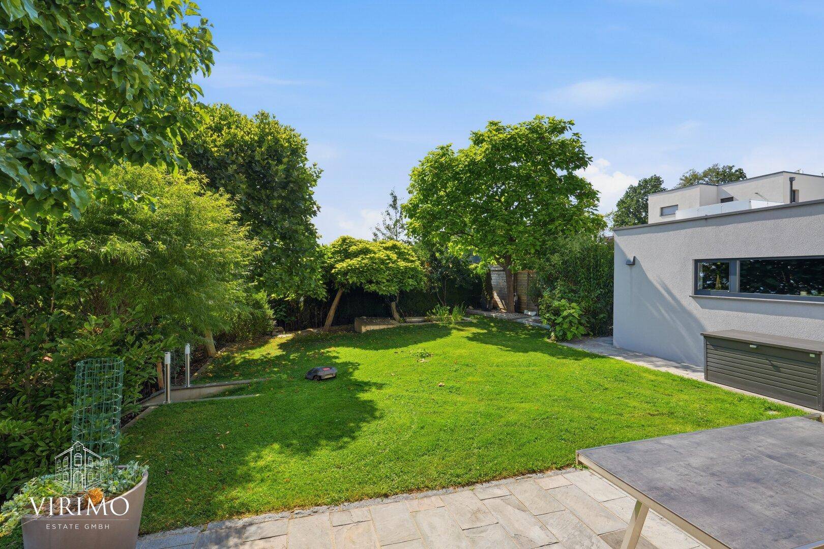 Weitläufiger Garten mit altem Baumbestand und gepflegter Rasenfläche.