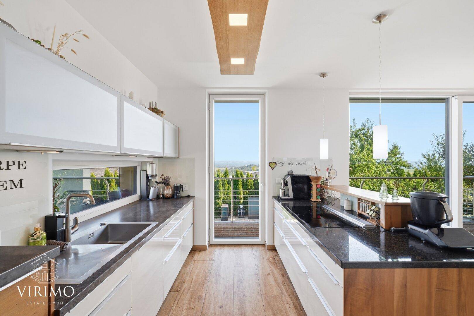 Helle Küche mit viel Tageslicht, Holzfußboden und Zugang zu einem kleinen Balkon.