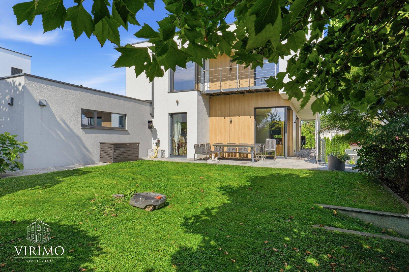 Großer Rasenbereich mit Terrasse und Gartenmöbeln, ideal zum Entspannen.