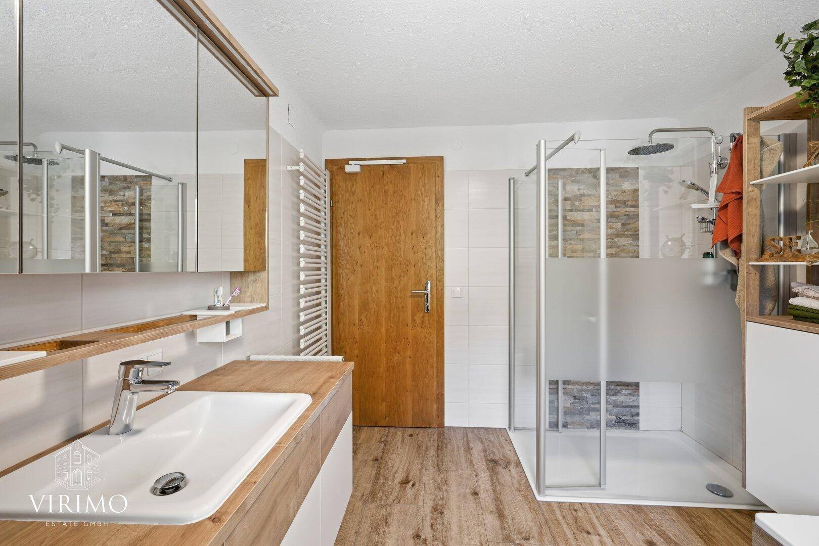 Modernes Badezimmer mit ebenerdiger Dusche, Einzelwaschbecken und Holzelementen.