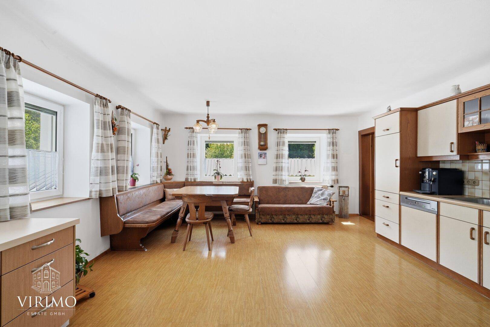 Traditionelle Wohnküche mit Eckbank, Esstisch und Einbauküche im Landhausstil.