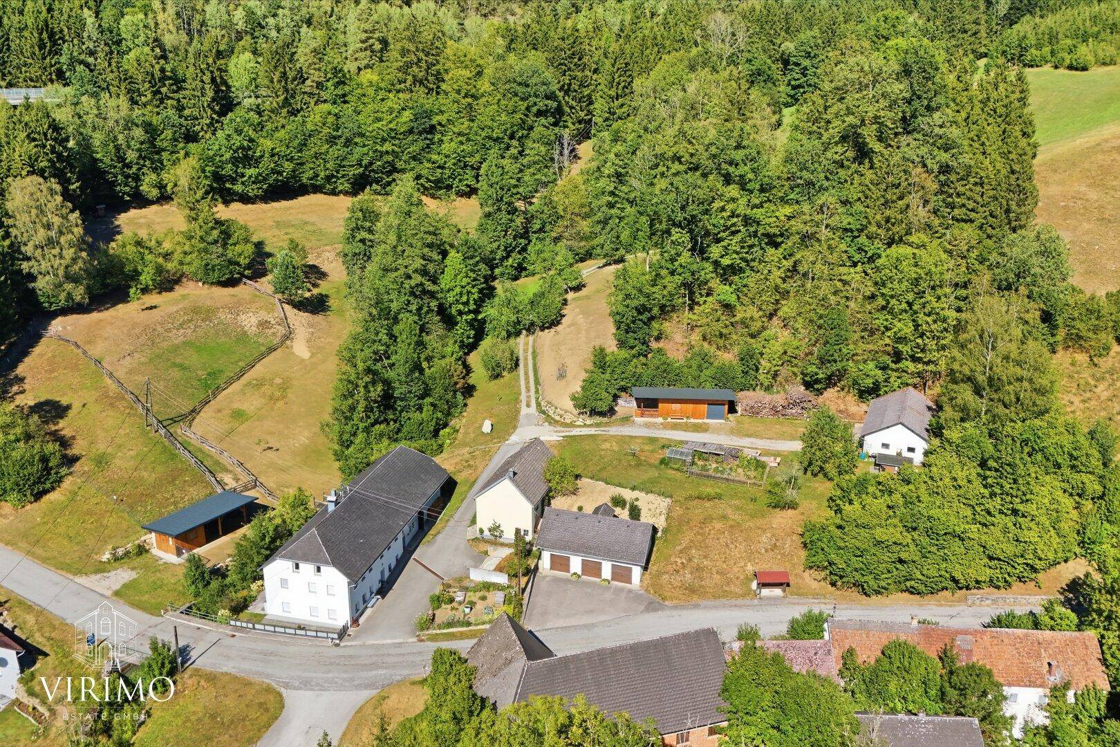 Panoramablick aus der Luft auf das ländliche Anwesen mit seinen Gebäuden und der Natur.