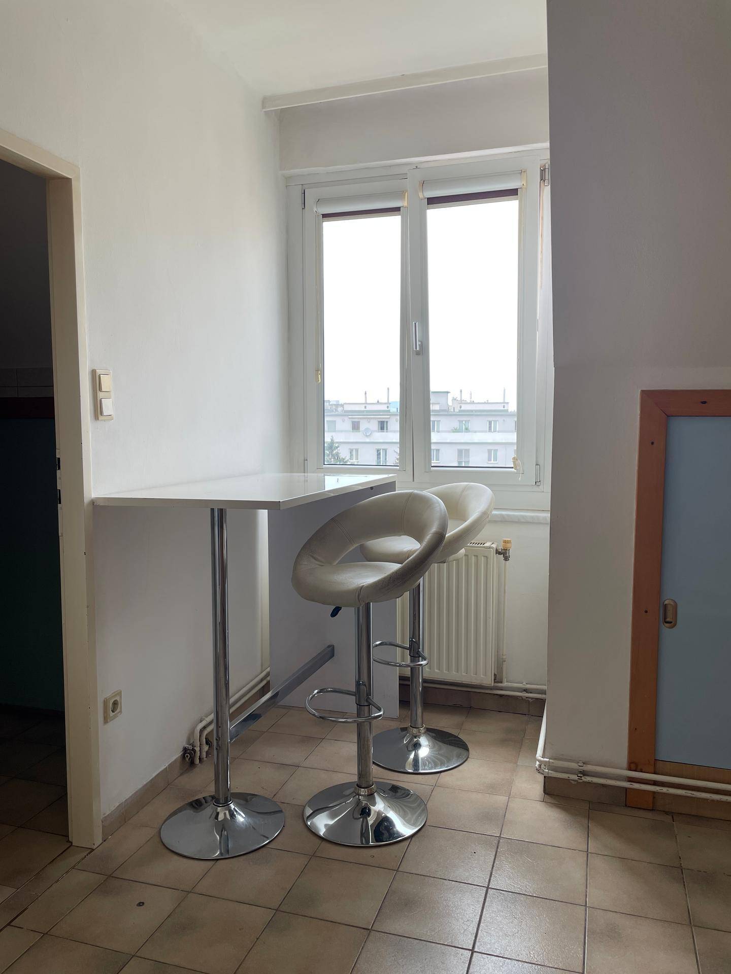 Küchenbereich mit Bartresen, Hockern und einem Fenster, das einen Blick nach draußen bietet.