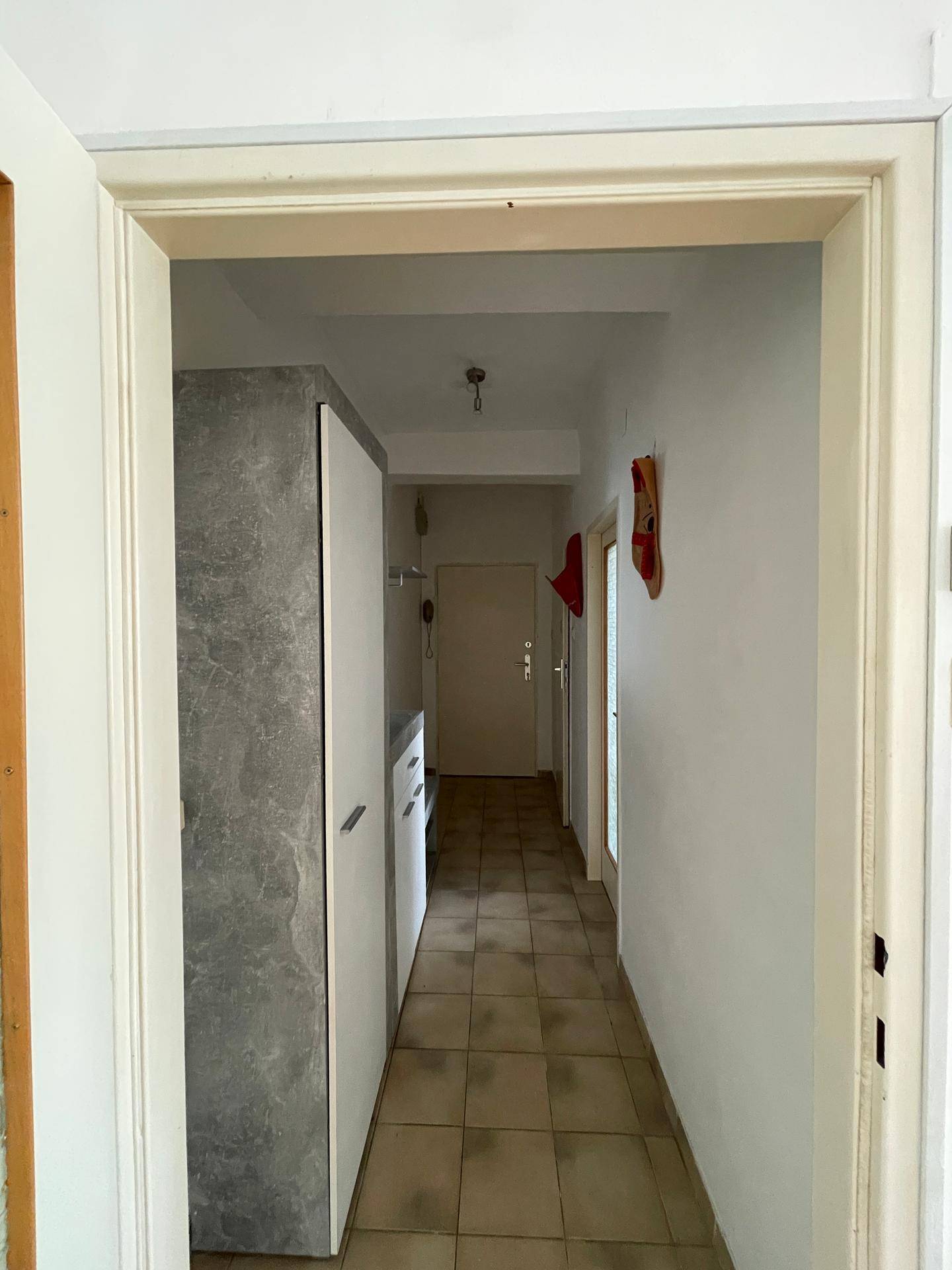 Heller Flur mit Fliesenboden und Garderobe, der den Zugang zu verschiedenen Räumen ermöglicht.