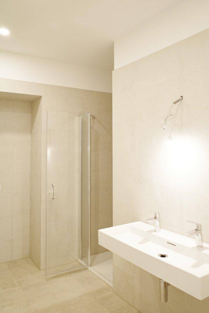 Modernes Badezimmer mit Doppelwaschbecken und einer Duschkabine.