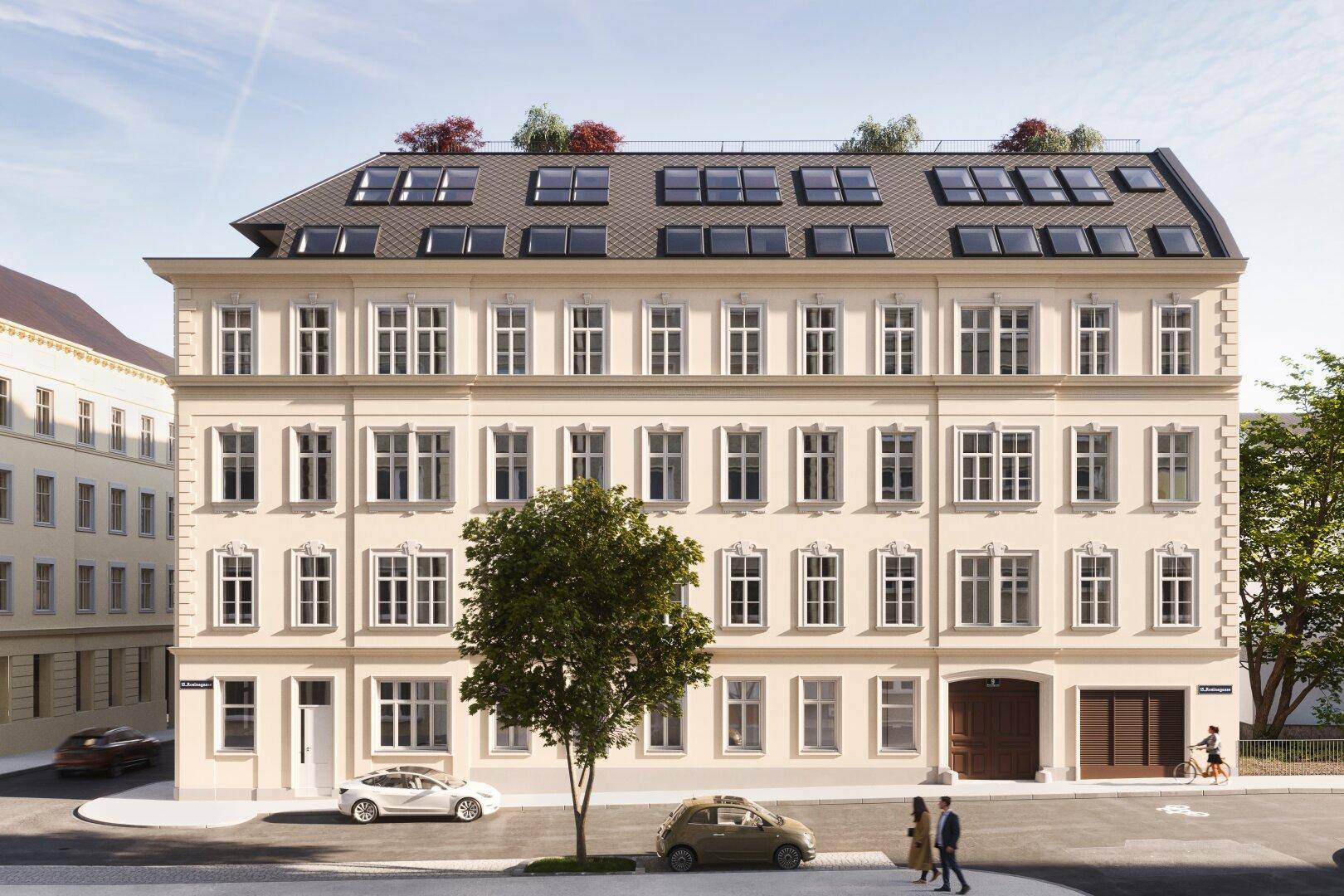 Fassadenansicht eines sanierten Altbaus mit vielen Fenstern und Mansarddach in der Stadt.