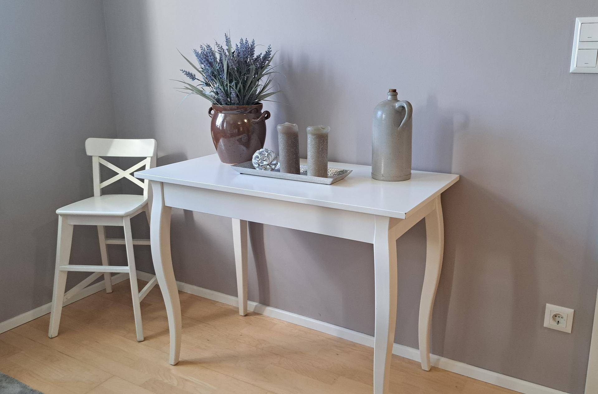 Heller Flur mit weißem Konsolentisch, Dekoration und hellem Holzfußboden.