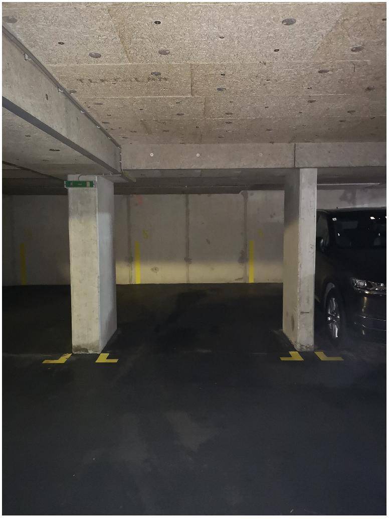Geräumige Tiefgarage mit Betonpfeilern und markierten Stellplätzen für Fahrzeuge.