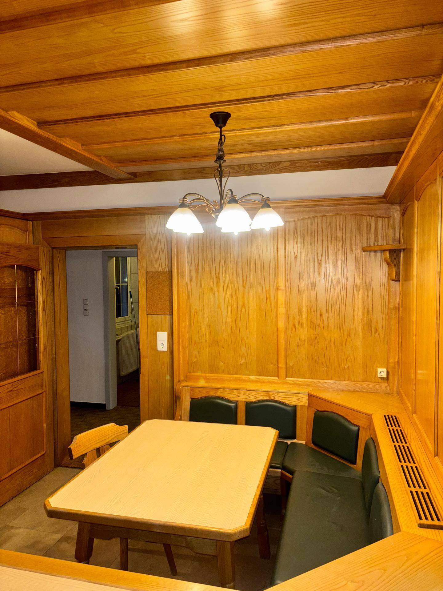Gemütlicher Essbereich mit Holztäfelung, Eckbank und traditionellem Holztisch.