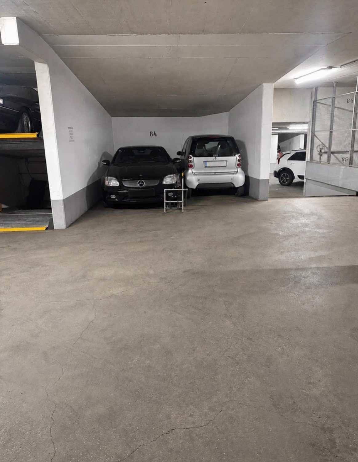 Tiefgarage mit mehreren Stellplätzen und Betonwänden.