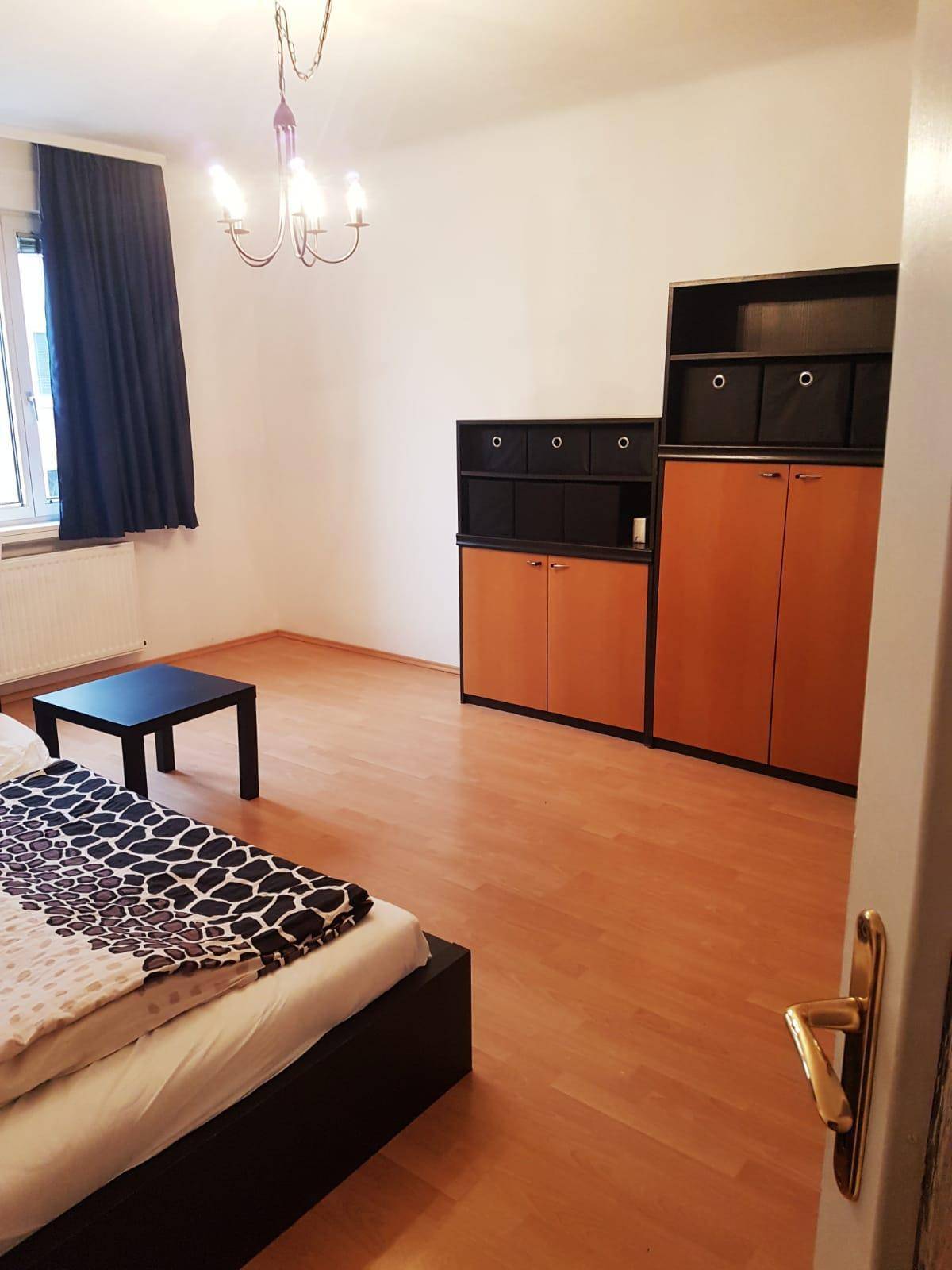 Schlafzimmer mit Laminatboden, Bett und Schränken, bereit zur individuellen Einrichtung.