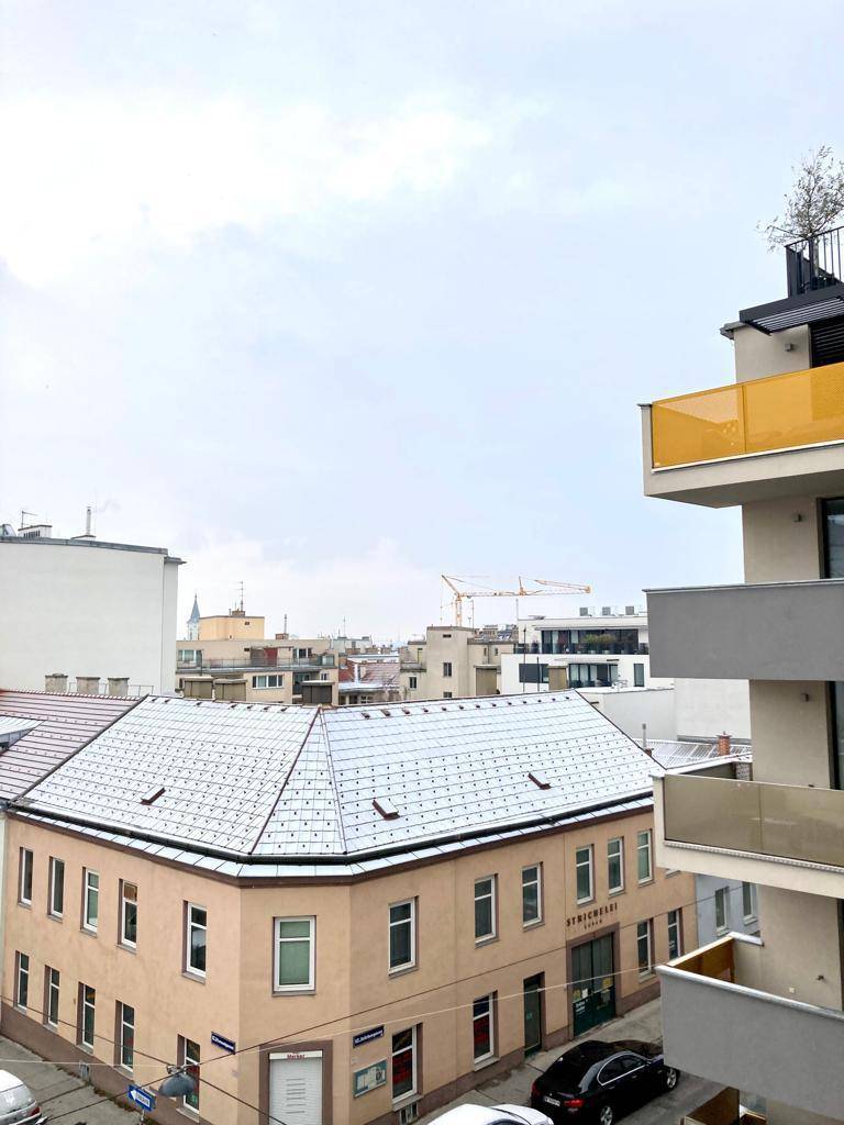 Blick über die verschneiten Dächer der Stadt mit umliegenden Gebäuden und einem Baukran.