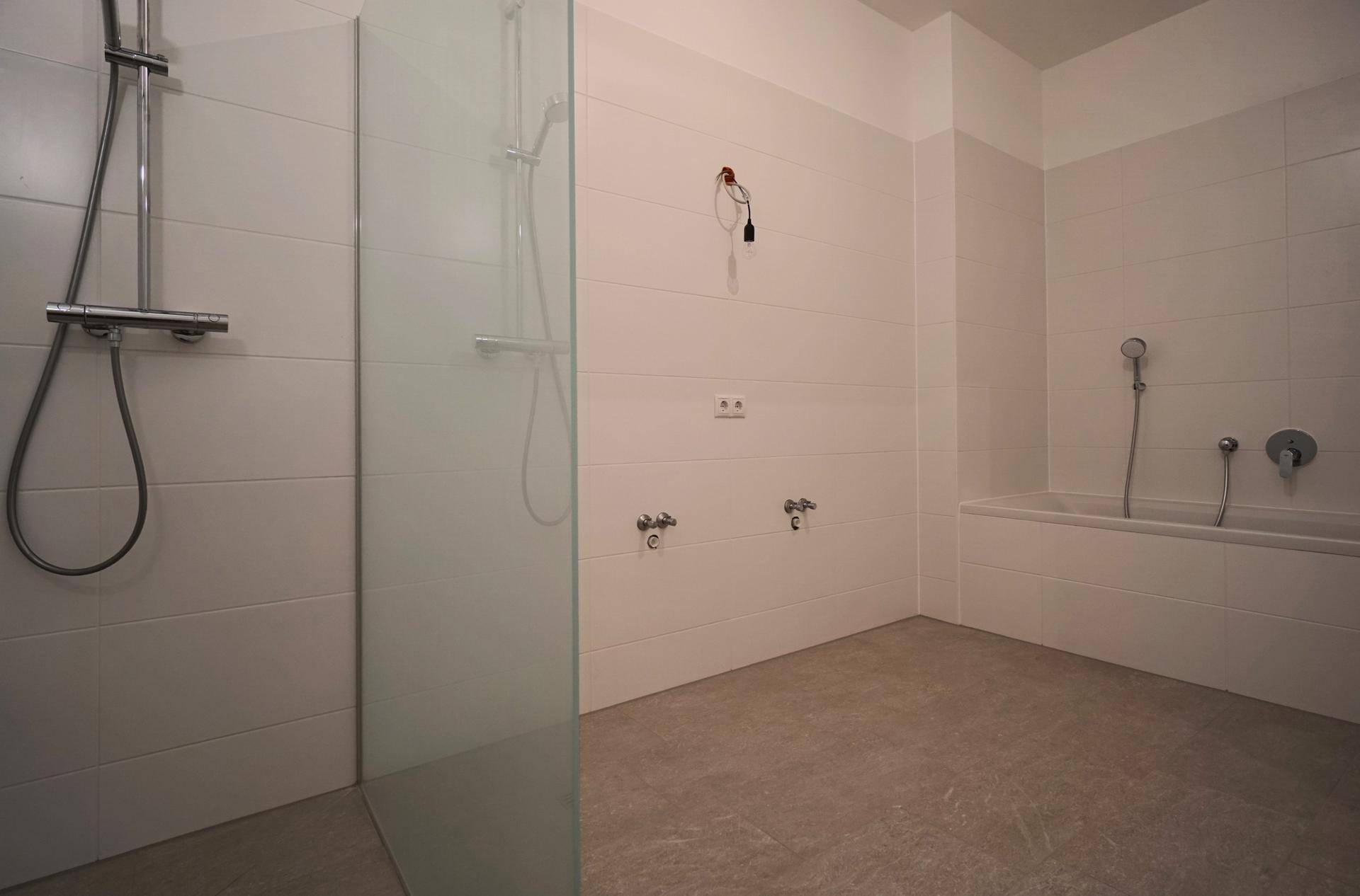 Modernes Badezimmer mit Badewanne, ebenerdiger Dusche und weißen Fliesen.