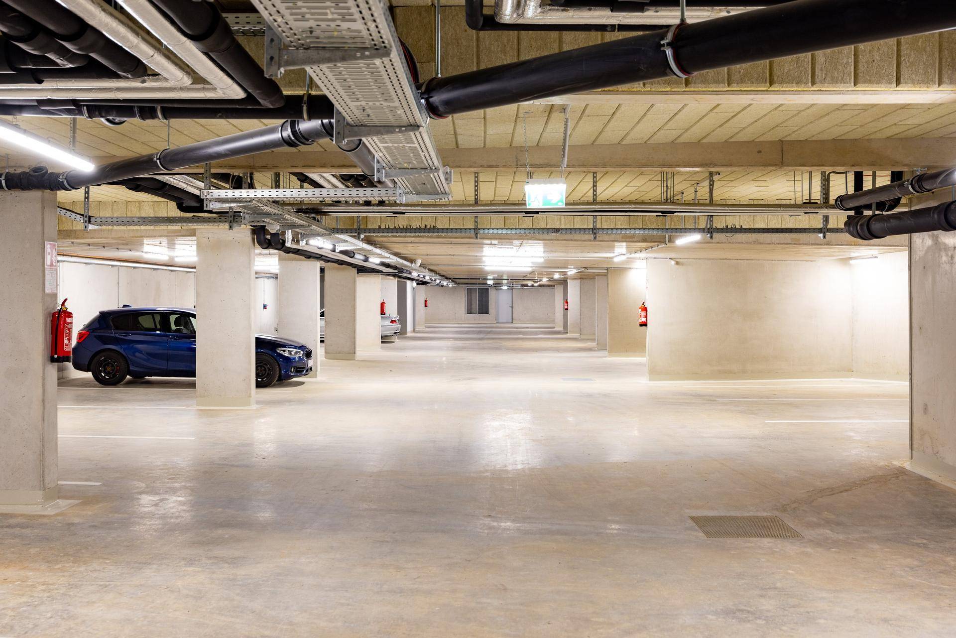 Geräumige Tiefgarage mit Betonboden und ausreichend Stellplätzen für Fahrzeuge.
