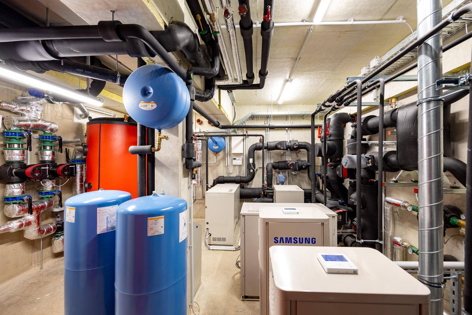 Umfassende Heizungsanlage mit mehreren Wärmepumpen und Verteilern im Technikraum.