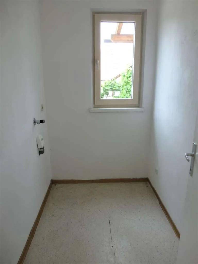 Kleiner Abstellraum mit Fenster und Anschlüssen, ideal als Speisekammer oder Hauswirtschaftsraum.