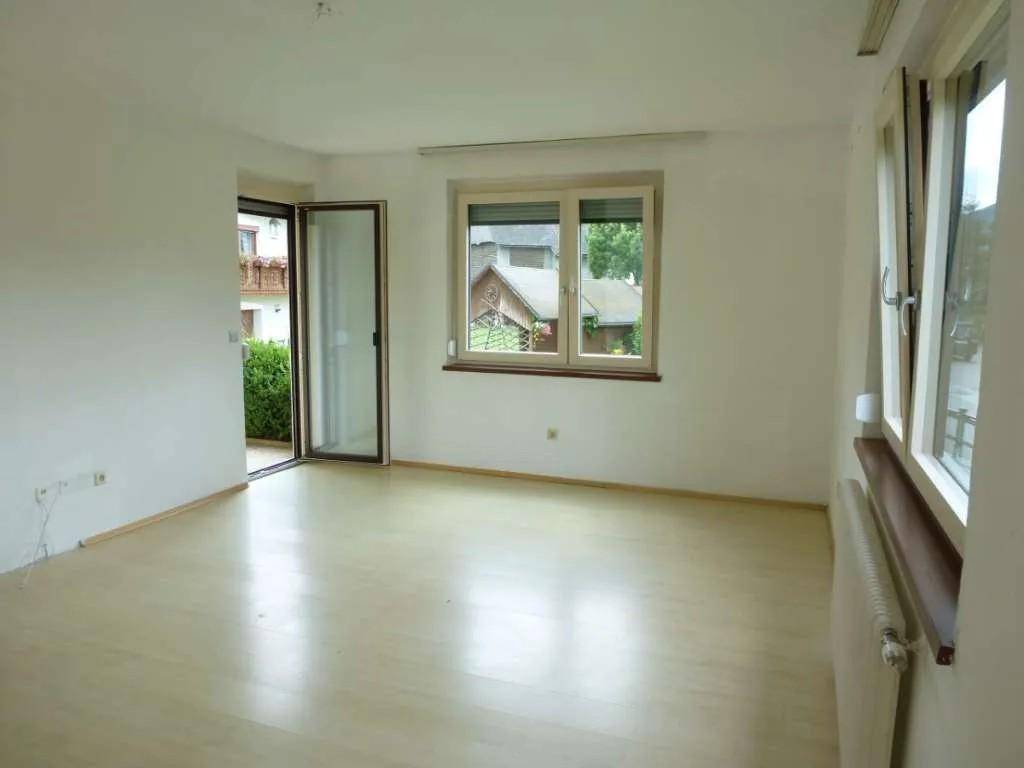 Lichtdurchflutetes Zimmer mit Zugang zum Balkon und hellem Laminatboden.