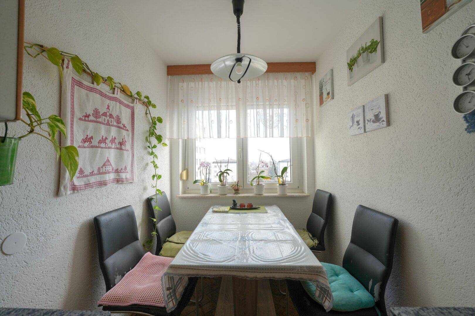 Gemütlicher Essbereich mit Tisch und Stühlen, direkt am Fenster gelegen.