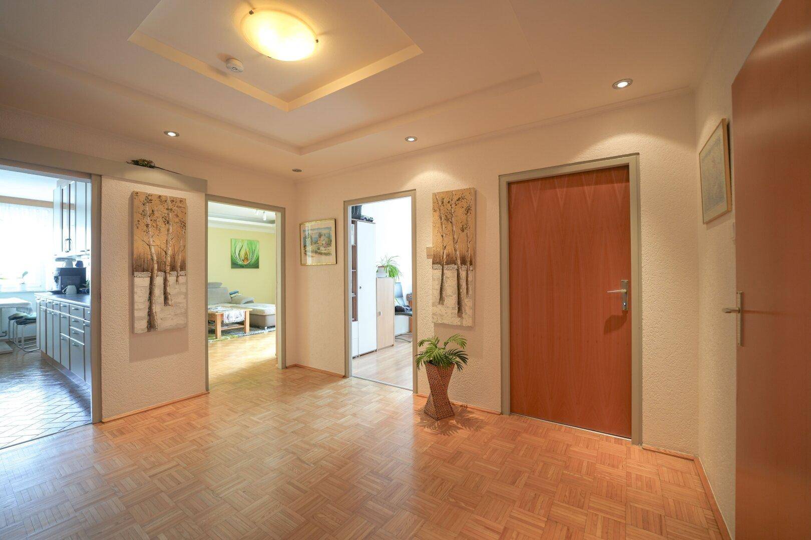 Heller Flur mit Parkettboden und Zugang zu verschiedenen Zimmern der Wohnung.