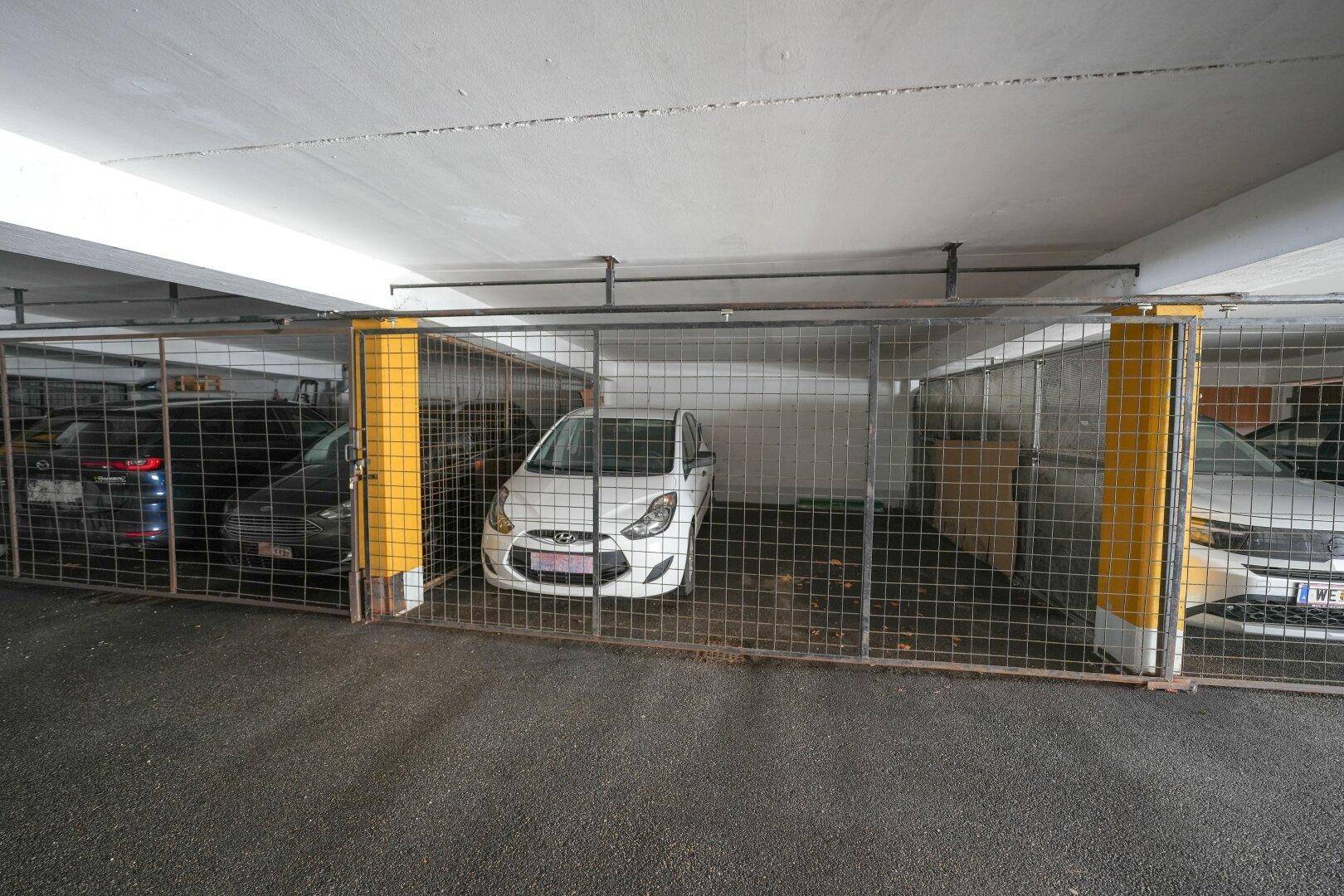 Abgeschlossene Stellplätze in der Tiefgarage mit Gitterabtrennungen für Fahrzeuge.