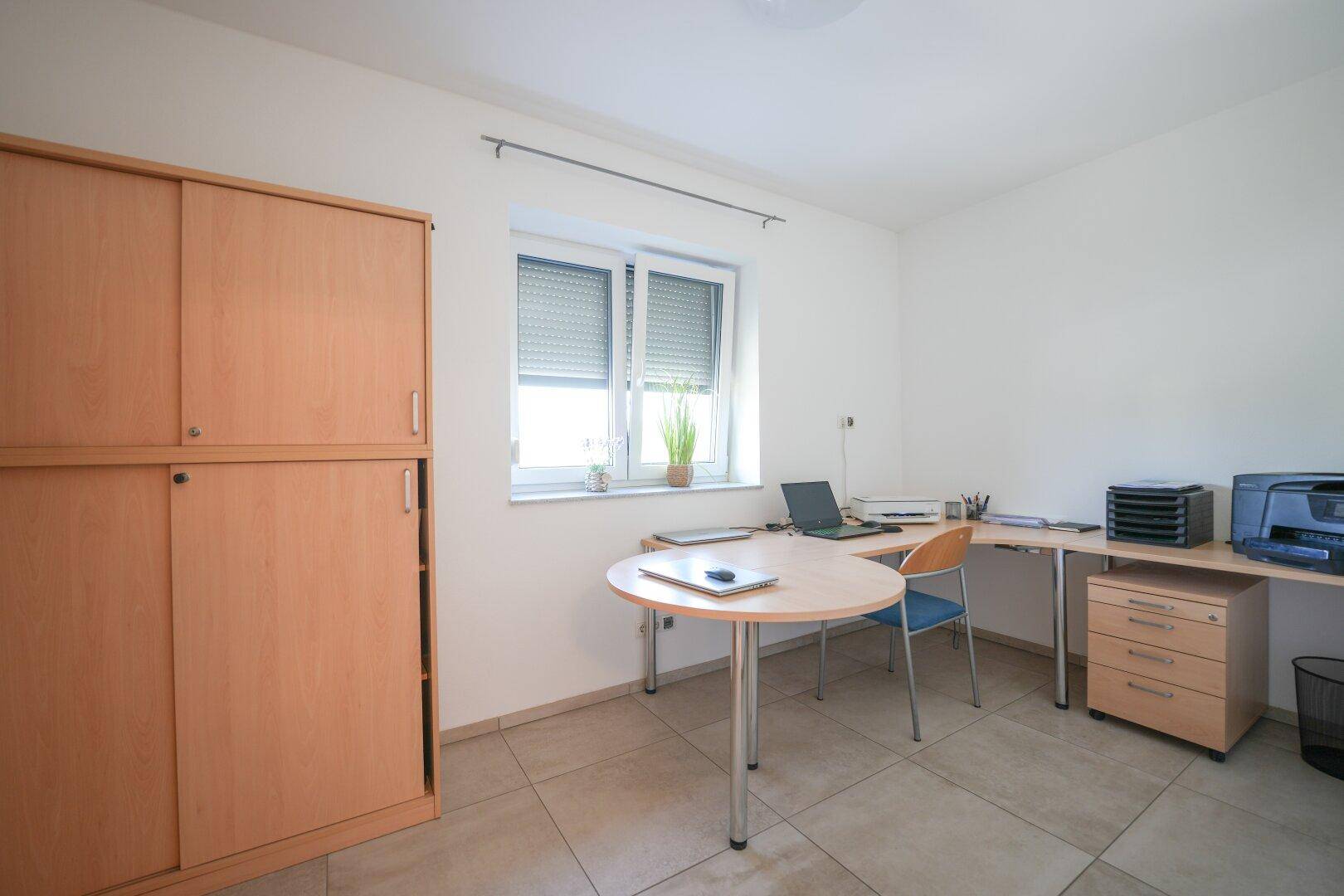 Funktionales Arbeitszimmer mit Schreibtisch, Bürostuhl und einem Fenster für gute Belichtung.