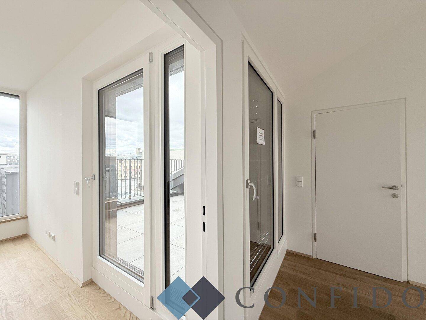 Eckzimmer mit großen Fenstern und Zugang zur Terrasse, bietet viel Licht und Ausblick.
