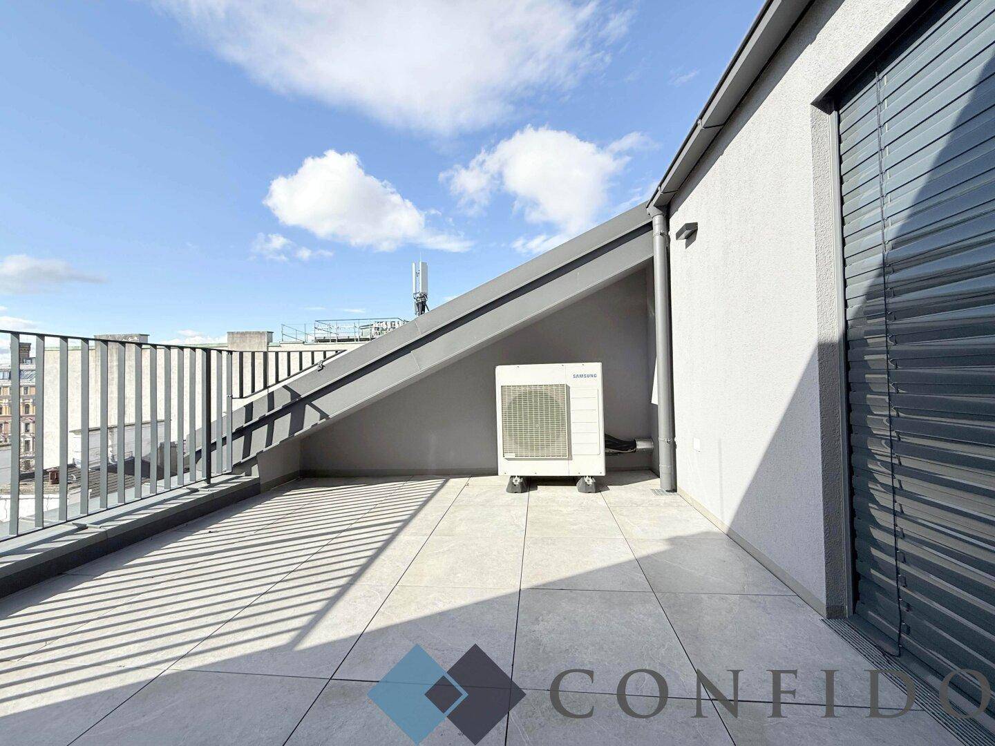 Sonniger Terrassenbereich mit Fliesenboden und Außeneinheit der Klimaanlage, bietet Weitblick.