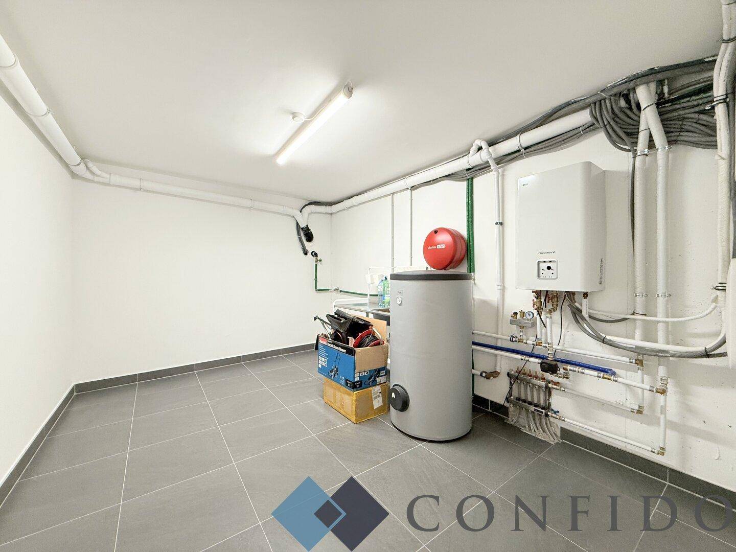 Technikraum im Keller mit Heizungsanlage, Warmwasserbereiter und ordentlichen Installationen.