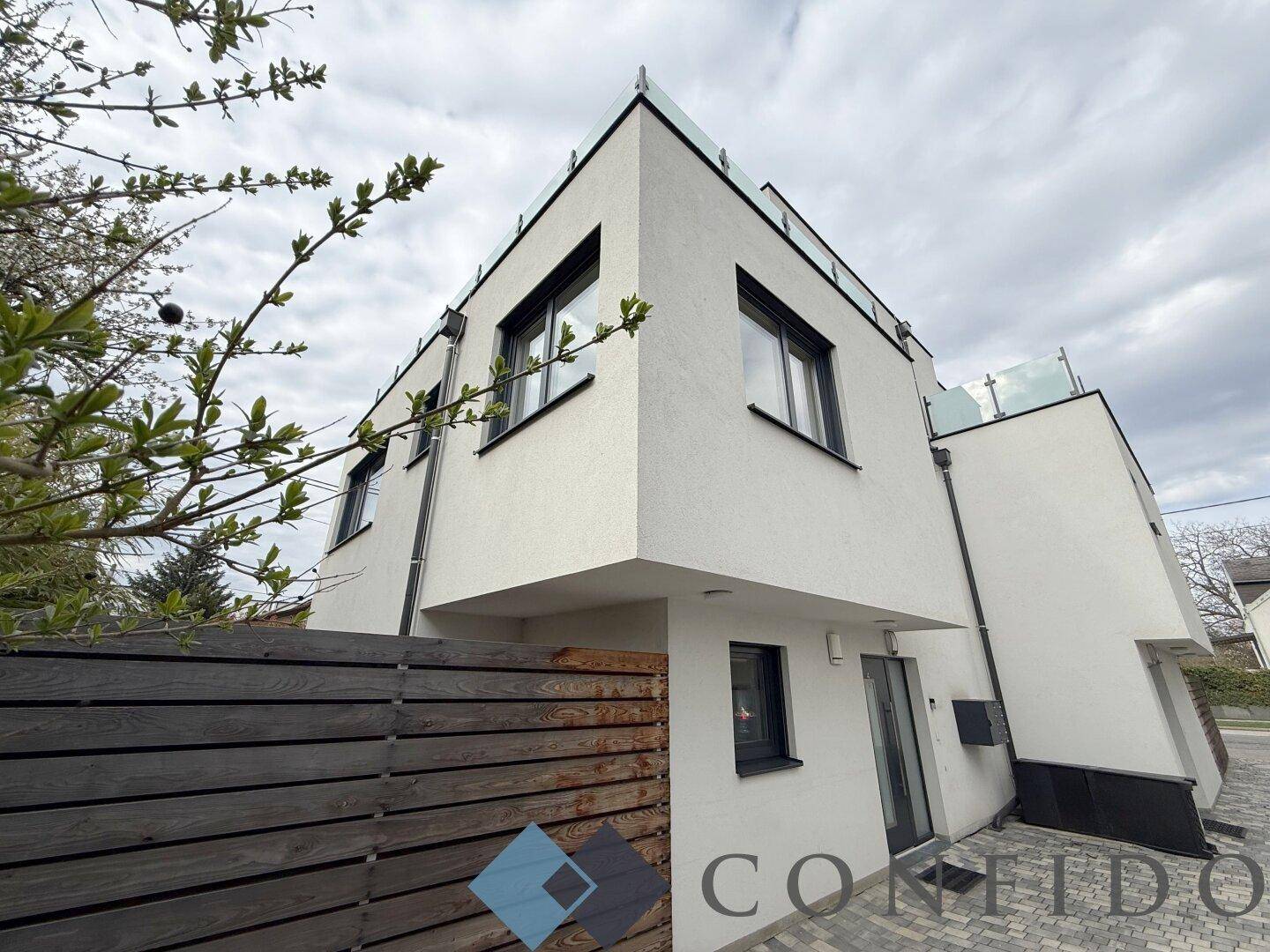 Zeitgenössische Architektur des Hauses mit klaren Linien und Flachdach unter bewölktem Himmel.