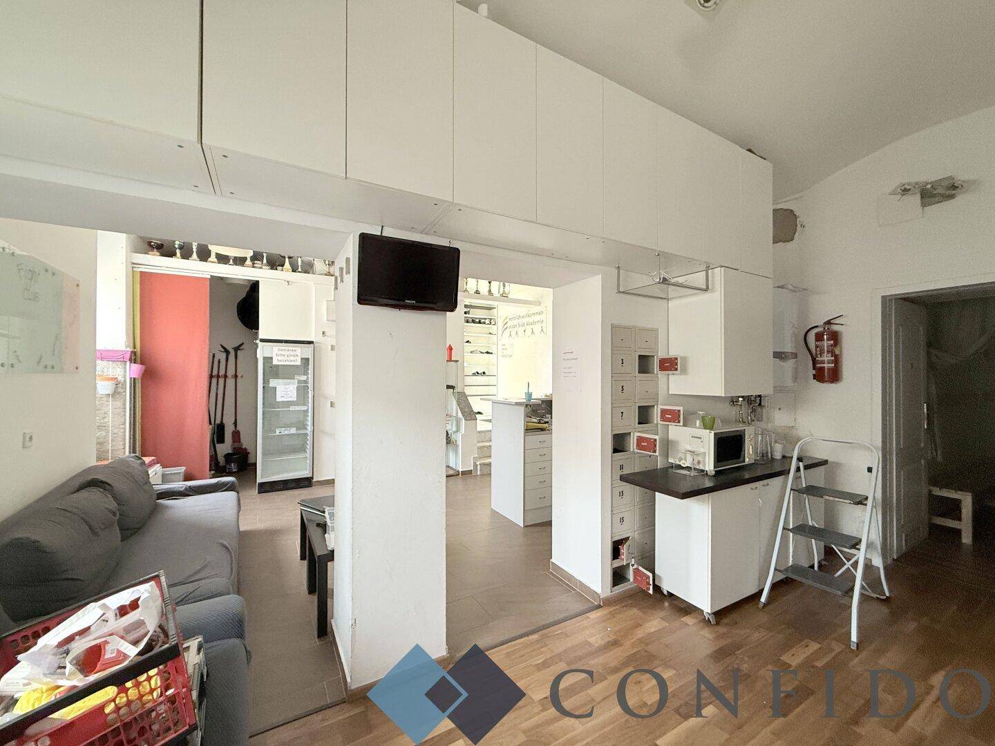 Gemütlicher Aufenthaltsbereich mit Sofa und kleiner Küchenzeile, ideal für Pausen.