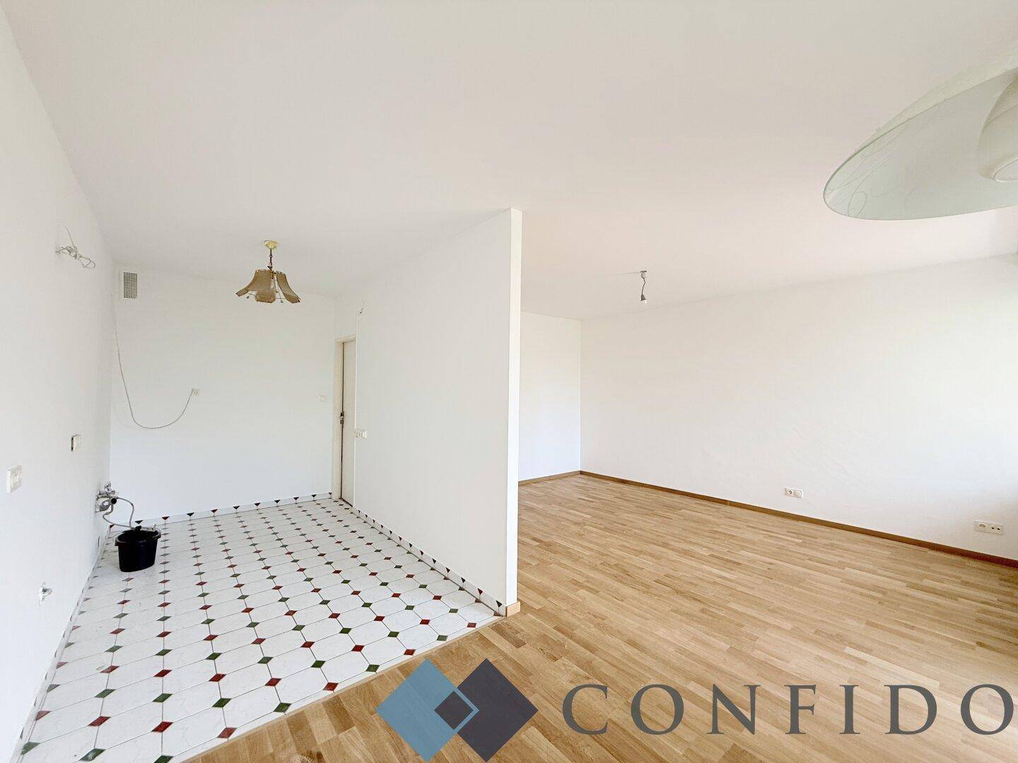Übergangsbereich zwischen gefliestem Eingangsbereich und Zimmer mit Parkettboden.