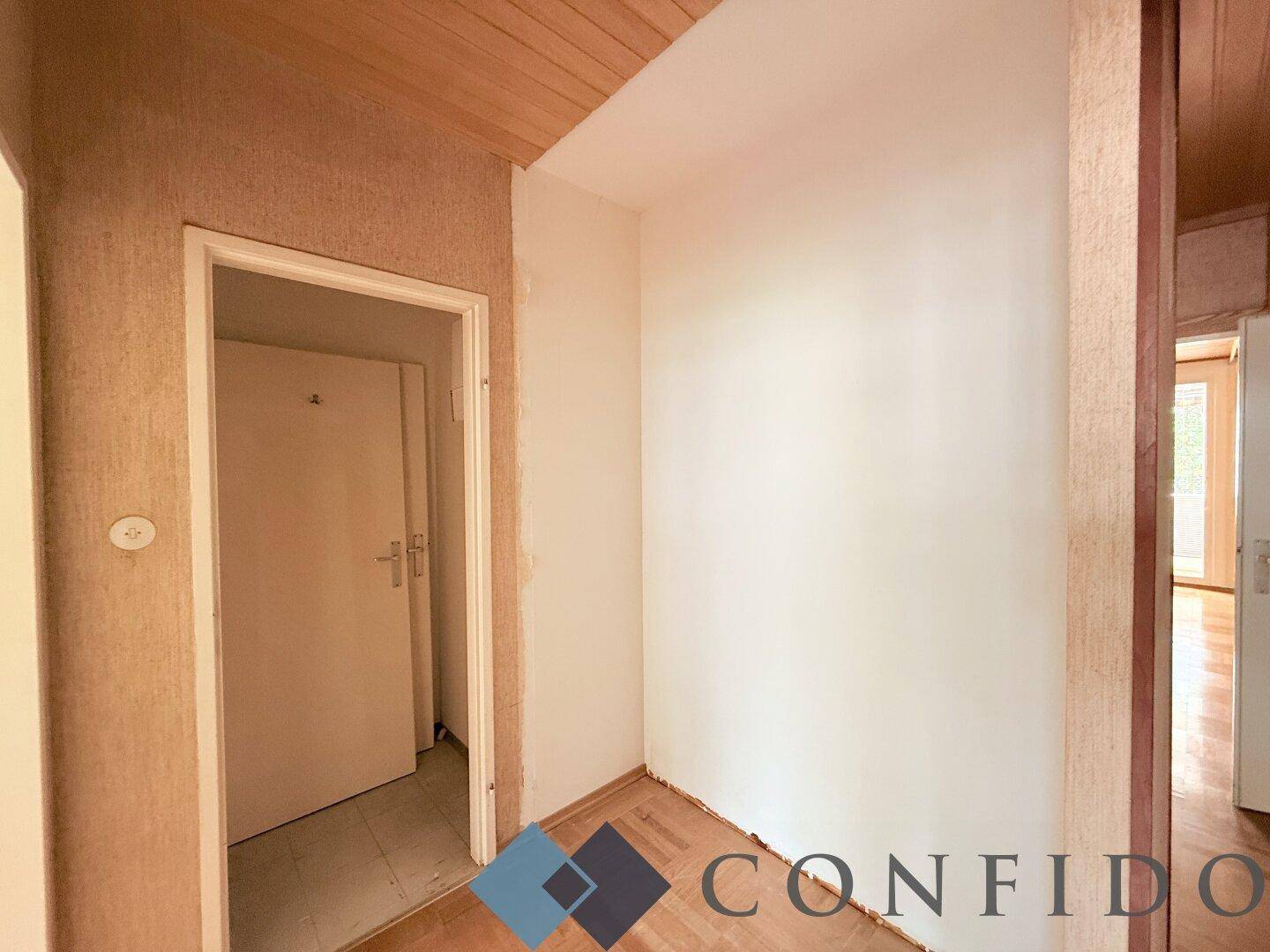 Flur mit Parkettboden, Holzdecke und Zugang zu weiteren Räumen der Wohnung.