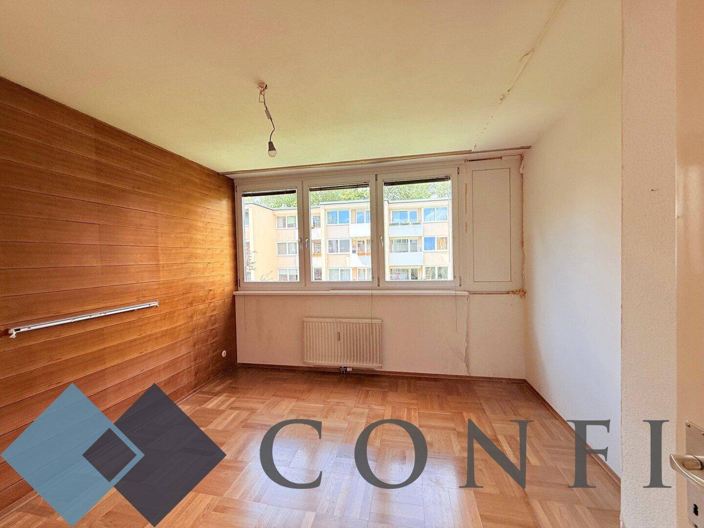 Schlafzimmer mit Parkettboden, Holzwandverkleidung und Blick auf die Nachbarschaft.